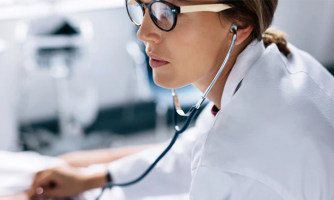 doctor with stethoscope listening to patient heartbeat
