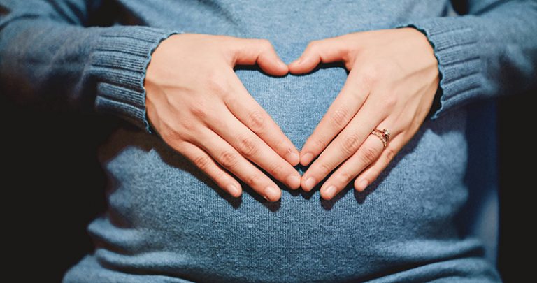 heart hands over pregnant belly